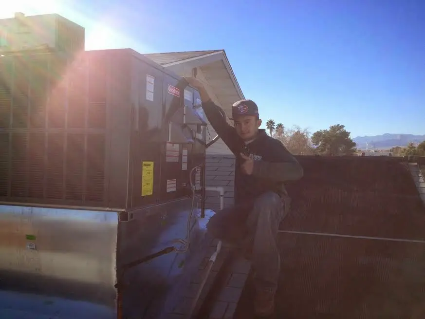 HVAC technician performing HVAC Inspection on a rooftop unit in Leland